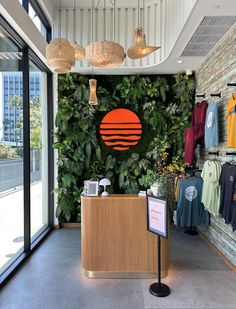 the inside of a clothing store with plants growing on the wall