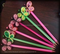 several different colored pencils are lined up in a row on a wooden table,