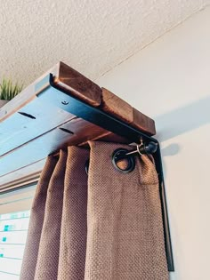 a curtain is hanging on the side of a window sill with a tie bar attached to it