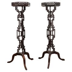 a pair of tall metal candlesticks with intricate designs on each candle holder and stand