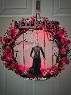 a wreath with a statue in the center and hellraier on it's front door