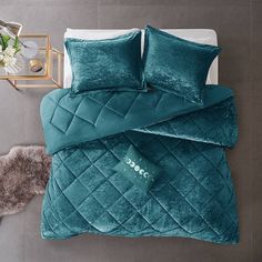 a bed with green comforters and pillows