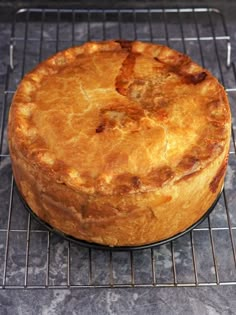 a baked pie sitting on top of a metal rack