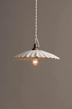 a light that is hanging from a ceiling with a white umbrella on the top of it