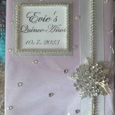 the wedding album is decorated with silver and pearls on it's cover, as well as a snowflake brooch