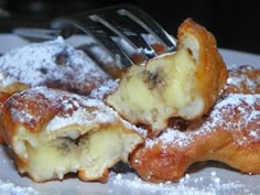 powdered sugar covered pastries on a plate with a fork