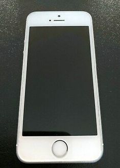 an iphone sitting on top of a table next to a black surface with a white button