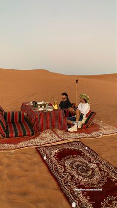 two people sitting on a couch in the desert