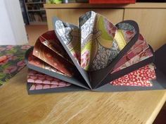 several folded paper pieces sitting on top of a wooden table