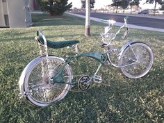 two bicycles are parked in the grass near a tree