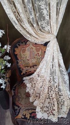 an old chair is covered with lace and flowers