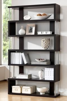 a book shelf with books and a vase on top