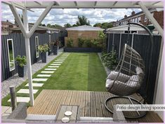 a small backyard with grass and wooden decking