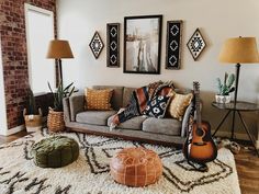 a living room filled with lots of furniture and pictures hanging on the wall above it