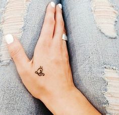 a woman's hand with a small tattoo on it