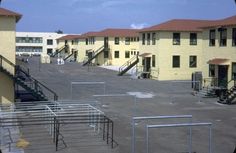 an empty parking lot with several buildings in the background and stairs leading up to them