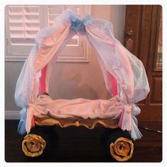 a doll's bed made to look like a carriage