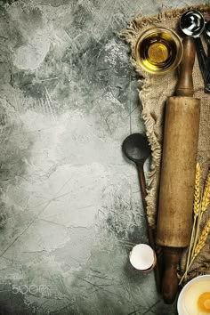 an overhead view of cooking utensils and ingredients on a rustic table cloth with spoons