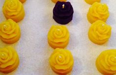 there are many yellow cupcakes with purple frosting on the top and bottom