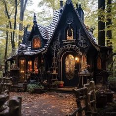 a black and white house in the woods with lights on it's front door