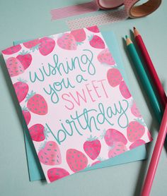 a card that says wishing you a sweet birthday with strawberries on it and two pencils next to it