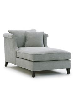 a gray chaise lounge chair sitting on top of a white floor