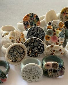 a collection of ceramic objects sitting on top of a white table next to each other