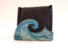 a blue and white ceramic wave sitting on top of a black piece of cloth,