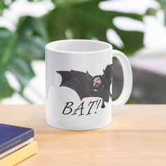 a white coffee mug with an image of a bat on it