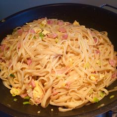 a pan filled with pasta and vegetables on top of a stove