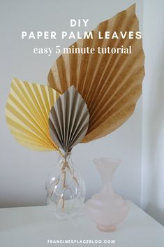 a paper fan sitting on top of a table next to a vase