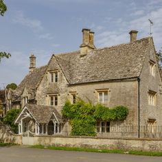 an old stone house with ivy growing on it's roof