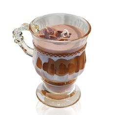 a glass cup filled with liquid on top of a saucer and covered in chocolate