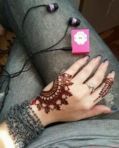 a woman's hand with henna tattoos on it