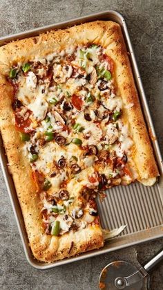 a pizza sitting on top of a pan covered in cheese and veggie toppings