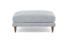 the footstool is upholstered with wood legs and a light blue velvet cover