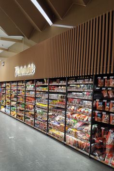 a grocery store filled with lots of food and drink bottles on display in front of the wall