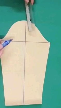 someone is cutting out a piece of paper with scissors and glue on the end of it