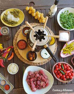 an assortment of food is displayed on a table with utensils and sauces