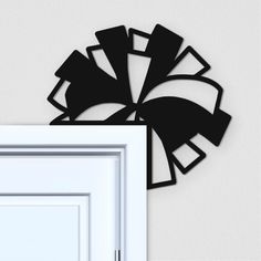 a black and white wall hanging next to an open door with the frame cut out