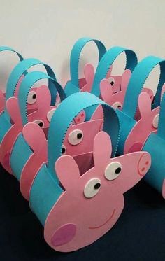 some pink and blue paper cups with eyes on them are lined up in the shape of peppa pig