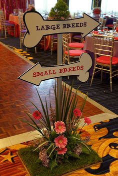 a sign in the middle of a room with tables and chairs