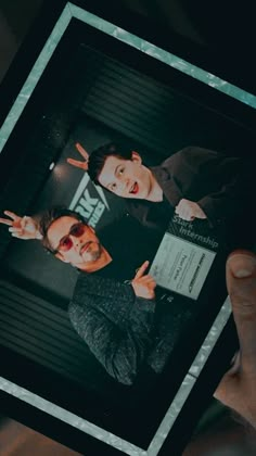 two young men are posing for the camera with their hands in front of them,