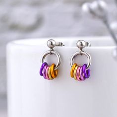 Subtly express trixic (NBLW) pride with these minimalist earrings on stainless steel stud posts. The lightweight colorful links are carefully selected to best match the colors of the trixic pride flag. Comfy and lightweight for everyday wear.  💜 lightweight aluminum links on durable stainless steel ear post 💛 earrings measure 0.5" long from top of stud 🧡 extra ear backs included (extras may be different style)  Note: If you'd like the 4-color trixic flag in yellow, white, pink and violet please send a convo and I'll set up a custom listing for you! ➡️ Prefer sterling, gold or hypoallergenic earwire? Customize your upgrade here: https://www.etsy.com/listing/1157028577/  ➡️ Want 2 different flags? Check out the Mix n Match option: https://rebecamojicajewelry.etsy.com/listing/1486724308 👀 Trixic Flag, Trixic Pride, Different Flags, Earring Minimalist, Pride Colors, Pride Flag, Pride Flags, Minimalist Earrings, Stud Earring