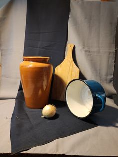 two vases, one with a wooden handle and the other with a ceramic bowl