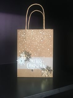 a brown paper bag with white snowflakes on it and merry christmas written on the front