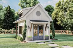 a small white house sitting on top of a lush green field