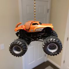 a toy monster truck hanging from a chain