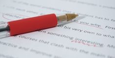 a red pen sitting on top of a piece of paper