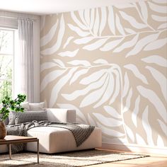 a living room scene with focus on the couch and wall papered in white leaves